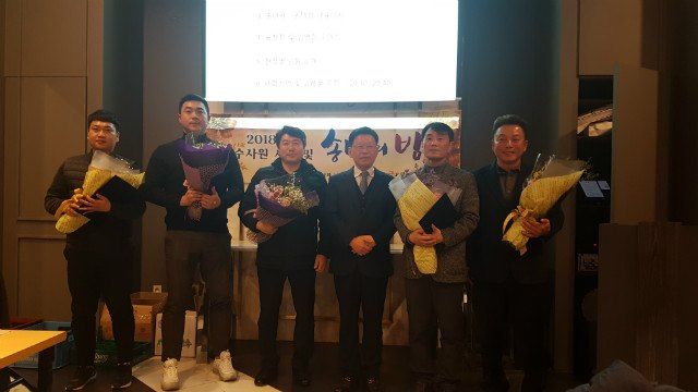 「우수사원 시상 및 송년의 밤」 무대 앞에서 꽃다발을 든 2019년 진급자들