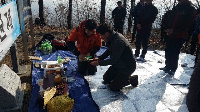 제단 앞에 무릎 꿇고 잔을 올리는 임원들